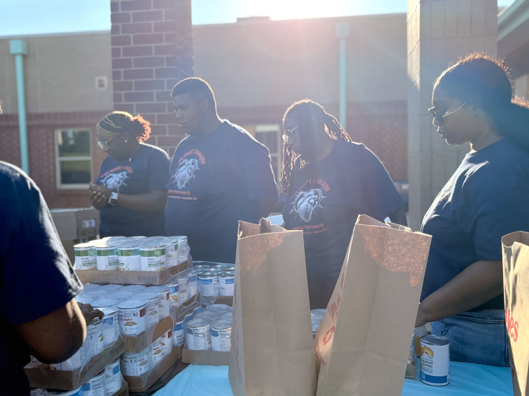 Volunteers packing canned goods into grocery bags