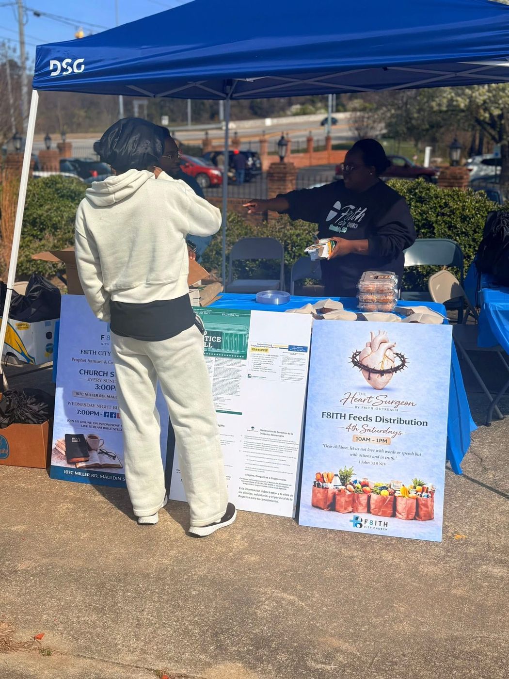 A neighbor visiting the F8ith Feeds Distribution tent